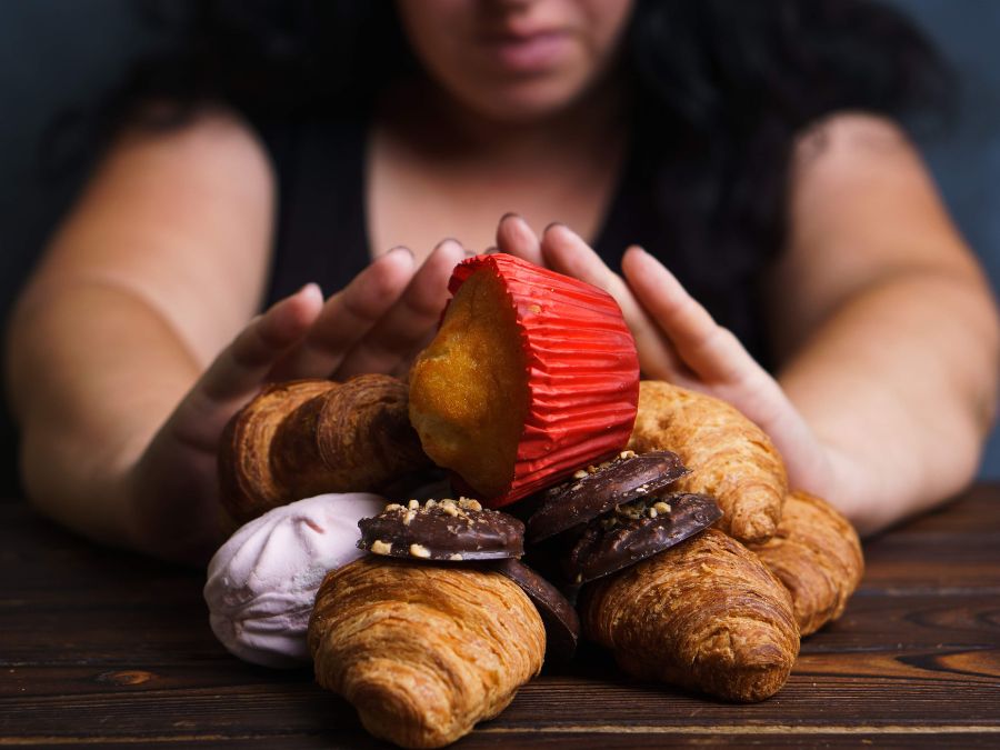 Femme repoussant des pâtisseries — apaiser les compulsions alimentaires